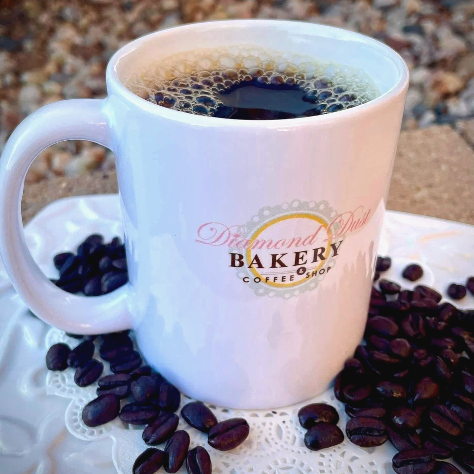 Diamond Dust mug of coffee surrounded by coffee beans